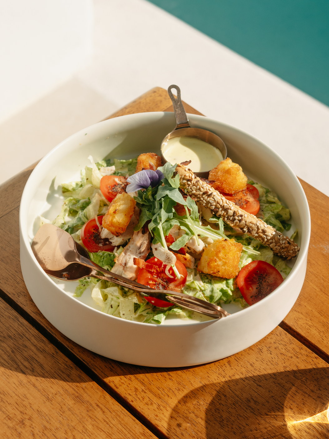 A salad of tomatoes and greens plated at Bard de Sol